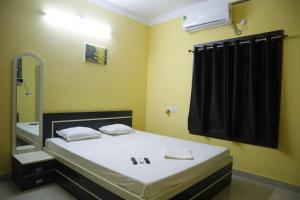 a bedroom with a bed and a mirror at Hotel Sahil Inn in Mandarmoni