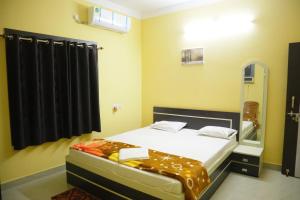 a small bedroom with a bed and a mirror at Hotel Sahil Inn in Mandarmoni