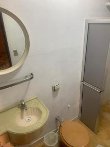 a bathroom with a toilet and a sink and a mirror at Pousada Casa do Fabio - Bikers point in Águas da Prata