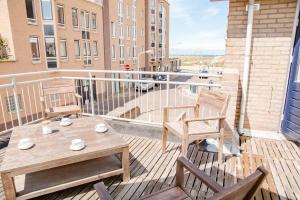 a balcony with two chairs and a wooden table and chairs at Emma's beach house in Katwijk aan Zee