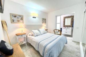 a white bedroom with a bed and a mirror at Seashell Beach House on the frontline of the ocean in Punta Mujeres