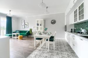 シュチェチンにあるEXCLUSIVE Nautica Apartmentsのキッチン、リビングルーム(白いテーブル、椅子付)