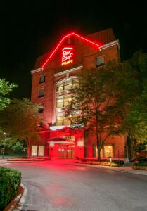 a building with a neon sign on the side of it at Red Roof Inn PLUS+ Columbus Downtown - Convention Center in Columbus