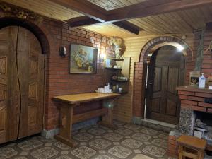 布克维Cottage Kalina的一间设有木桌和砖墙的客房