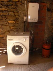 a washing machine sitting next to a brick wall at Tranquila casa de campo en Cedeira in Cedeira