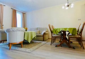 a living room with a couch and chairs and a table at Fortuna Golf Apartman in Bük