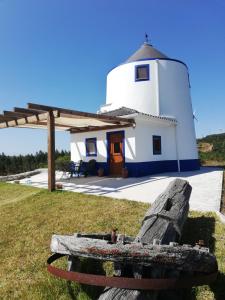 ein Leuchtturm mit einer Bank davor in der Unterkunft The Windhouse in São Bartolomeu