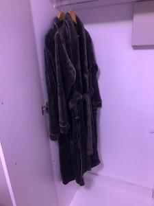a coat hanging on a wall in a closet at St Pete's Luxury Duplex Apartment - Perfect for the Single guest, Cosy Couple or the Friendly Family in Newton Park