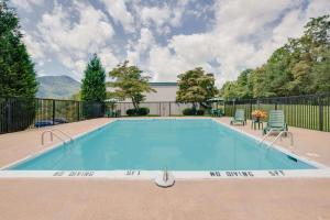 a swimming pool with two chairs and a table at Days Inn by Wyndham Asheville West in Candler