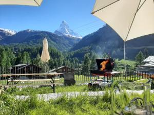 uma vista para uma montanha a partir de uma mesa com um guarda-chuva em House Mojo em Zermatt