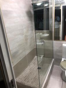 uma casa de banho com um chuveiro e um WC. em St Pete's Luxury Duplex Apartment - Perfect for the Single guest, Cosy Couple or the Friendly Family em Newton Park