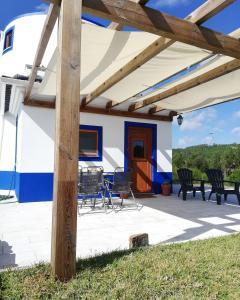 patio con sedie e tavoli sotto tenda da sole di The Windhouse a São Bartolomeu