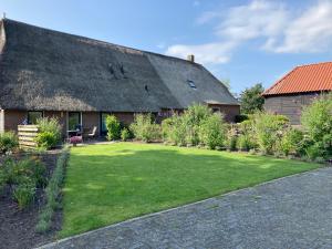 una casa con un patio de hierba delante de ella en De Deelderij, en Schoonloo