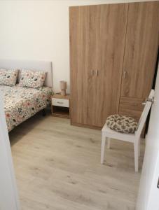 a bedroom with a bed and a chair and a cabinet at Apartamento Bornos&Huesca in Huesca