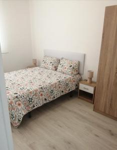 een kleine slaapkamer met een bed en een bijzettafel bij Apartamento Bornos&Huesca in Huesca