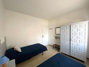 レスカラにあるRiells Platjaのベッドルーム(青いベッド1台、クローゼット付)