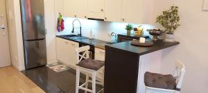 a kitchen with a black counter and a refrigerator at Apartment Jazz in Konstancin-Jeziorna