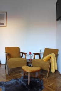 賈科沃的住宿－Studio apartman Hinko，客厅配有两把椅子和一张桌子