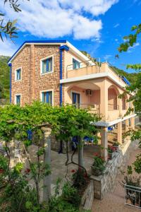 una casa con un jardín delante de ella en Apartmani Nica, en Sveti Stefan