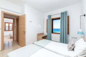 a bedroom with a bed and a window at Simon Studios and Apartments in Sitia
