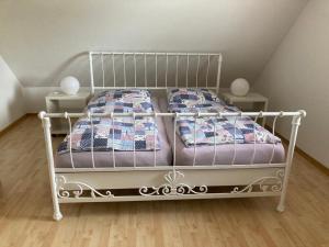 a white bed in a room with two tables at Marie Carla in Simonsberg