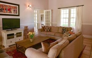 a living room with two couches and a television at Waterford House in Clarens