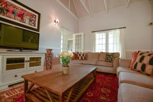 a living room with a table and a tv at Waterford House in Clarens