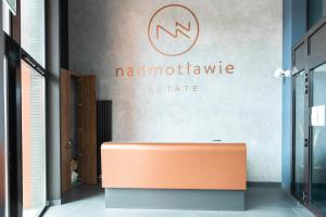 an orange bench in front of a sign on a wall at Old Town Nadmotławie - Sauna & Gym I 10min deptak in Gdańsk