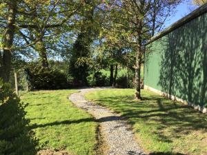 a gravel path next to a green fence at Orchardgrove apartment in Carlow