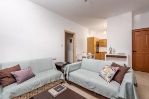a living room with a couch and a chair at Simon Studios and Apartments in Sitia