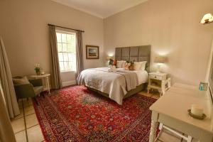 1 dormitorio con cama y alfombra roja en Waterford House, en Clarens
