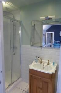 a bathroom with a sink and a shower with a mirror at The Crown Inn, Kemerton in Tewkesbury