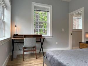 a bedroom with a desk and a bed and a window at The King Suite at Prince Street Inn ADA Accessible in Alexandria