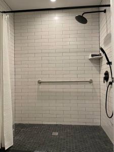 a bathroom with a shower with white tile walls at The King Suite at Prince Street Inn ADA Accessible in Alexandria