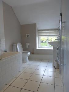 a bathroom with a tub and a toilet and a sink at The Crown Inn, Kemerton in Tewkesbury