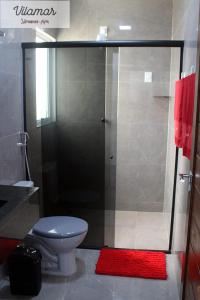 y baño con ducha, aseo y alfombra roja. en Vilamar en Tibau do Sul