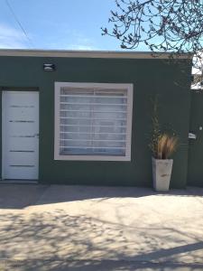 a green house with a window and a door at RoMa in Vista Flores