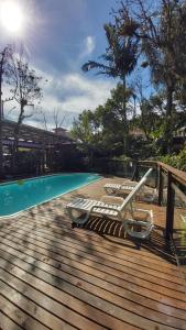 una terraza con tumbonas y una piscina en Stolz Chales, en Guarda do Embaú