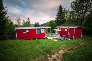 zwei winzige Häuser in einem Hof mit Badewanne in der Unterkunft RED Tiny Houses in Woronetz