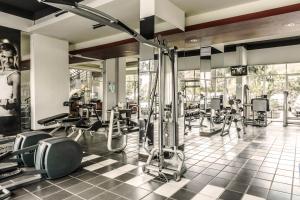 a gym with a lot of treadmills and machines at High Livin Apartment Baros in Cimahi