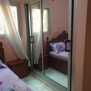1 dormitorio con una puerta de cristal que conduce a una cama en Résidence La ROSÉE en Yaundé