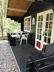 un porche de una casa con mesa y sillas en Zizania, en Noord-Sleen