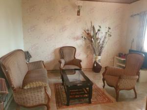 a living room with two chairs and a table at Résidence La ROSÉE in Yaoundé