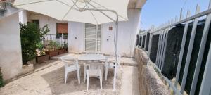una mesa y sillas con una sombrilla en el patio en A Casa di Stefy, en Santa Maria di Castellabate
