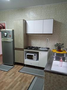 a small kitchen with a stove and a refrigerator at Residencial Recanto Paraíso BC - Apartamento in Balneário Camboriú