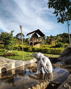 a statue of a woman sitting in a pond at VILLA DE LOS ANGELES GLAMPING in Anolaima