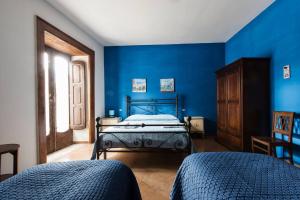 Schlafzimmer mit blauen Wänden und einem Bett in der Unterkunft Borgo San Lorenzello in San Lorenzello