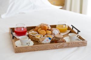 una bandeja de alimentos para el desayuno y bebidas en una cama en Relais Chalons d’Orange, en Pescasseroli