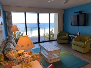 a living room with a couch and a table and a television at Updated Condo. Great for families. Seaside Beach and Racquet Club 5717 in Orange Beach