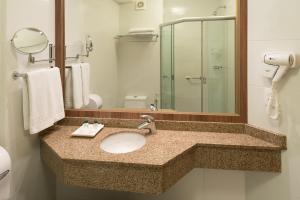 a bathroom with a sink and a mirror at Hotel Laghetto Viale in Gramado